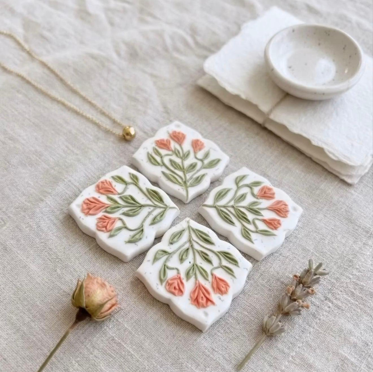 Coral Tulip Drops tiles laid out on linen before assembly