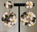 Daisy Meadow Drops: beige round earrings with white daisies on a stand