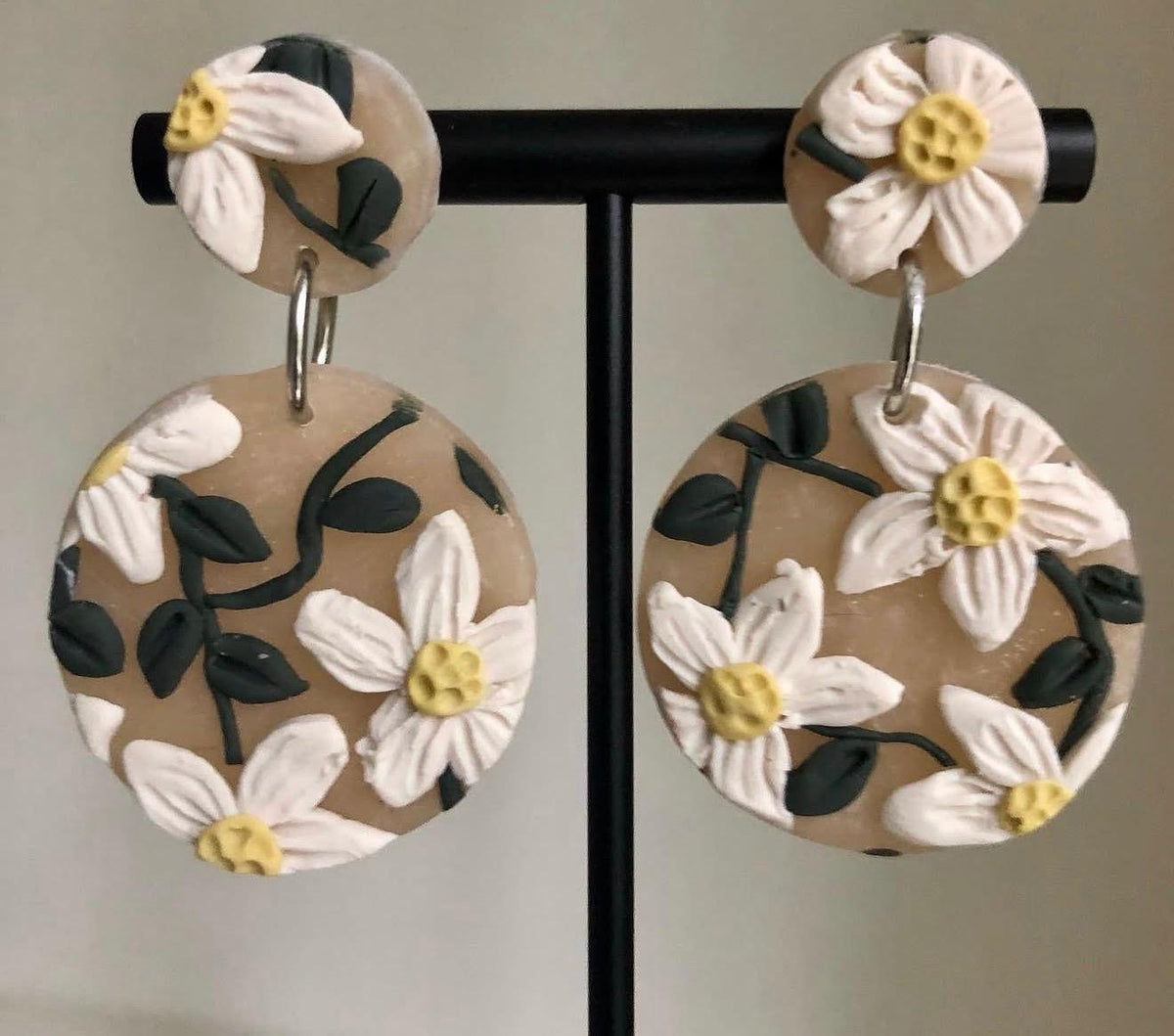 Daisy Meadow Drops: beige round earrings with white daisies on a stand