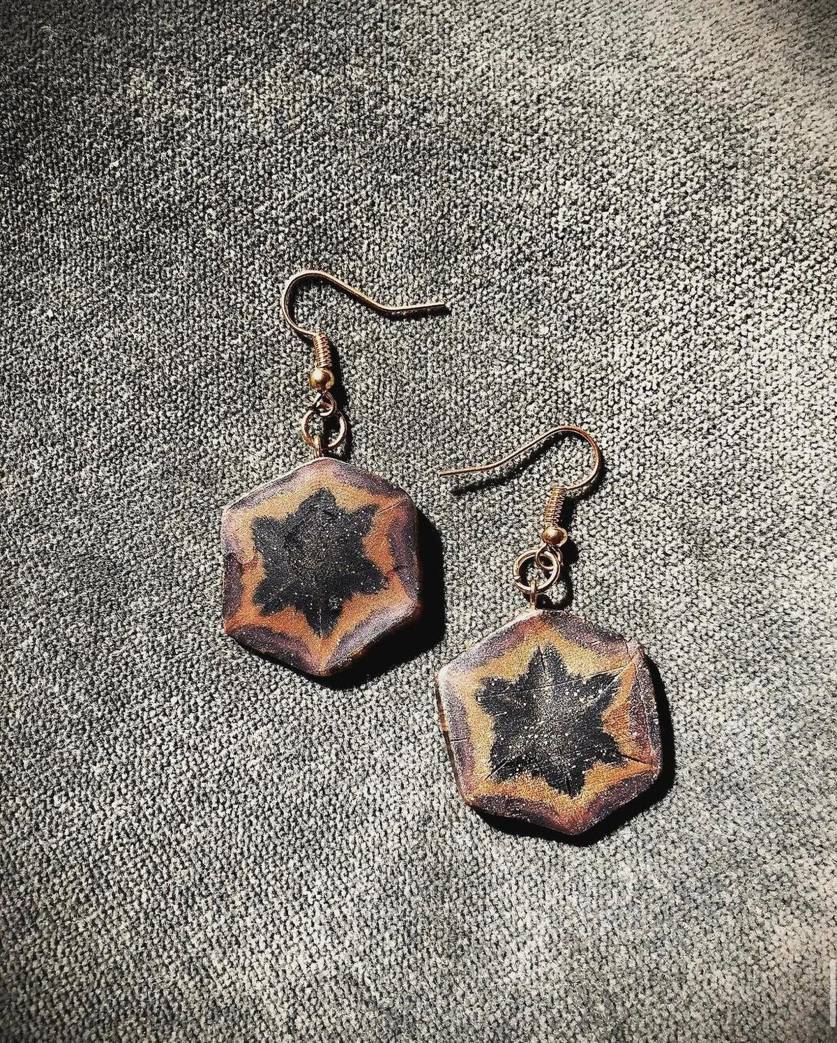 Ember Star Earrings: hexagon earrings in copper and amber with a dark star center