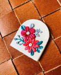 Fuchsia Arch Pendant: white arch with fuchsia and coral flowers and teal leaves