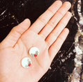 Holly Berry Studs: small white studs with holly leaves and red berries, held in a hand