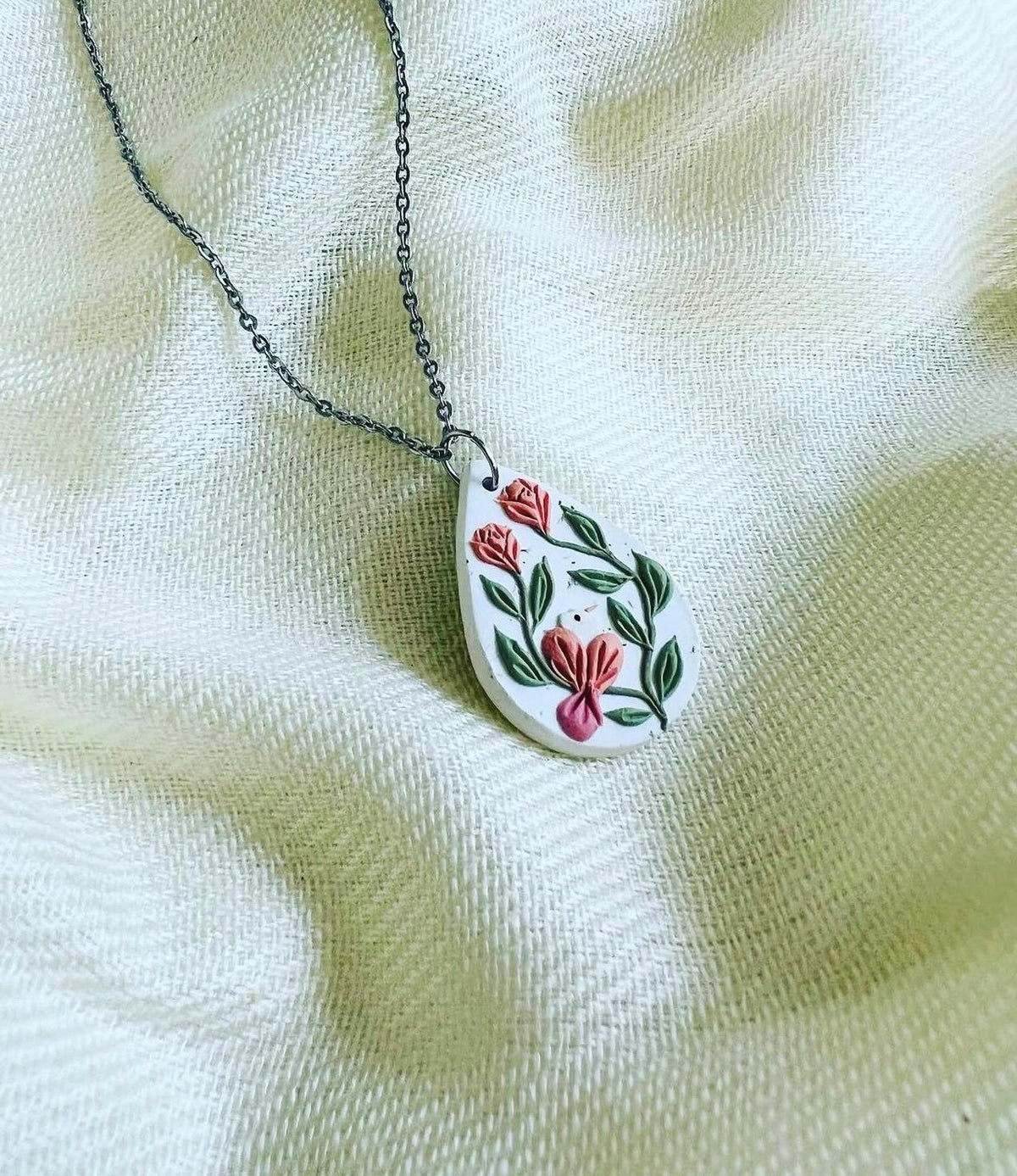 Rosebird Pendant: white teardrop pendant with a coral bird and red roses
