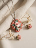 Terracotta Rose Pendant: terracotta pendant with a pink rose and sage leaves